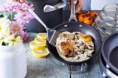 a person frying pancakes in a nonstick pan 